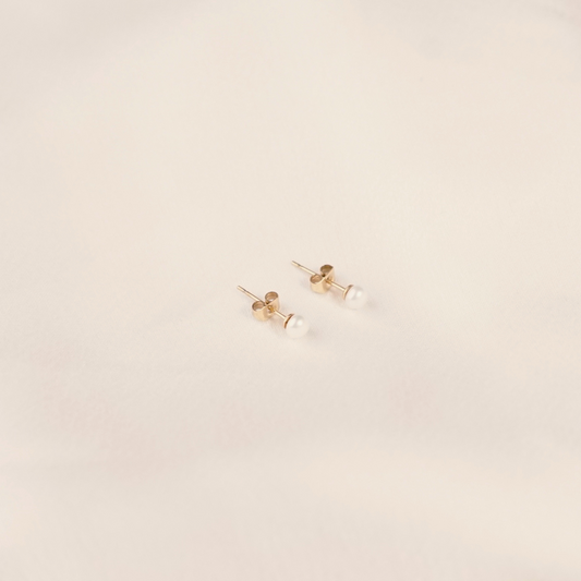 Edelstahl-Ohrringe mit Süßwasserperlen, goldfarben, minimalistisch, auf hellem Hintergrund