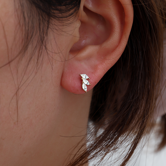 Ohrringe aus Edelstahl mit drei diamantförmigen Steinen, goldene Fassung, am Ohr getragen