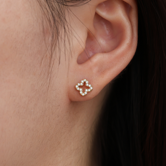 Diamond Hollow Clover Edelstahl Ohrring, goldfarben, Kleeblattform, mit kleinen funkelnden Steinen besetzt, am Ohr getragen