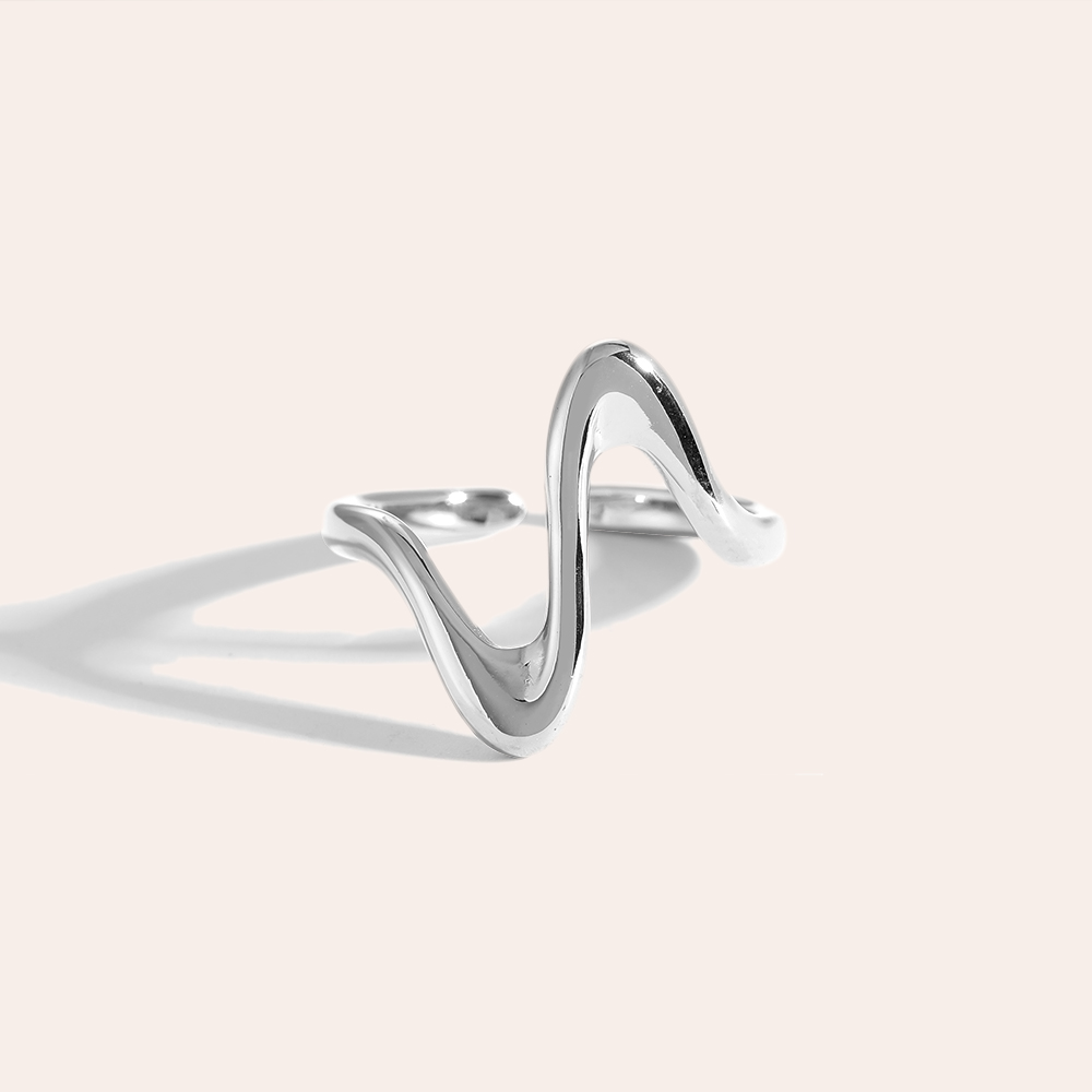 Silberner Edelstahlring in Herzschlag-Design mit wellenförmiger Struktur, glänzende Oberfläche, minimalistischer Stil