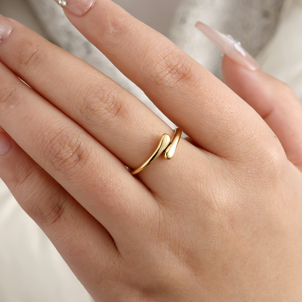 Goldfarbener Edelstahlring mit geschwungenem Design auf Finger getragen