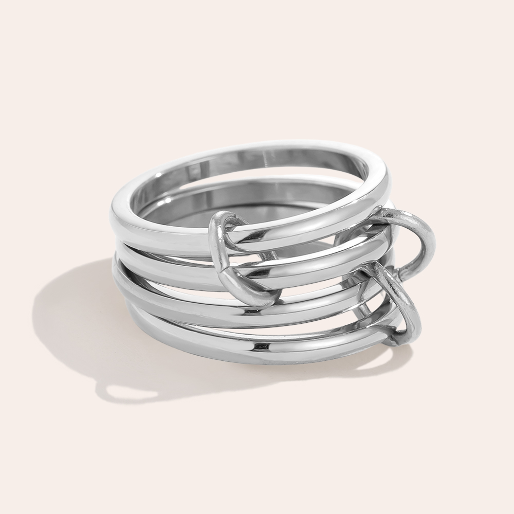 Silbernes Edelstahl-Ringset, bestehend aus mehreren ineinander verschlungenen Ringen, glänzende Oberfläche