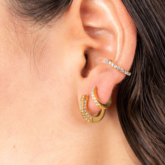 Goldener Edelstahl-Earcuff mit funkelnden Steinen, getragen am Ohr.