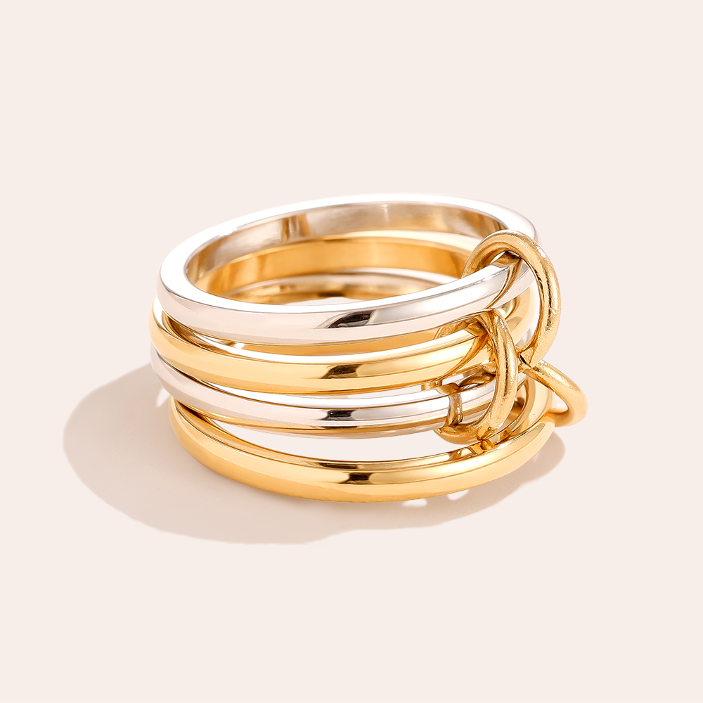 Set aus einfachen Edelstahlringen in Gold und Silber, gestapelt, mit schlichter, glänzender Oberfläche