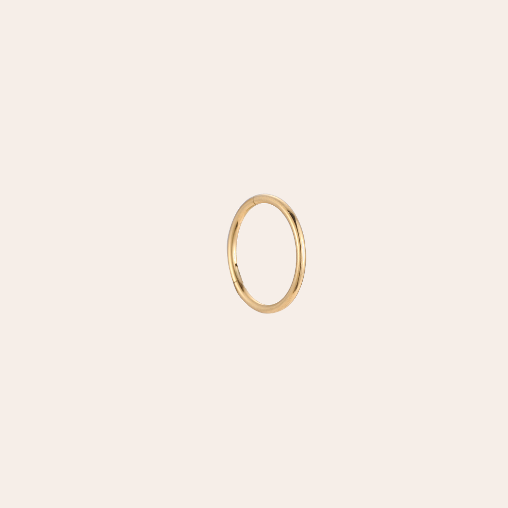 Goldenes Edelstahl-Piercing in perfekter Kreisform, schlichtes Design, glänzende Oberfläche