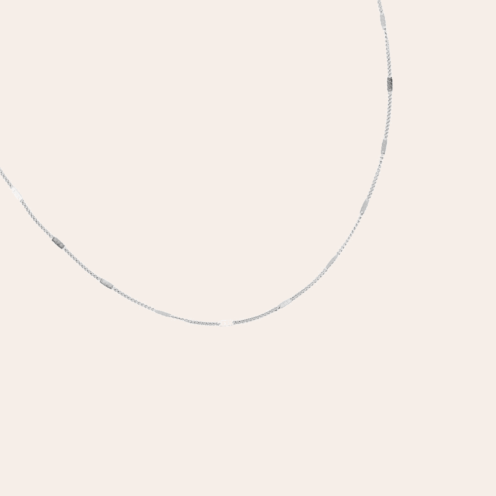 Silberne Edelstahlkette mit feiner Gliederung, minimalistisch und elegant, auf hellem Hintergrund.