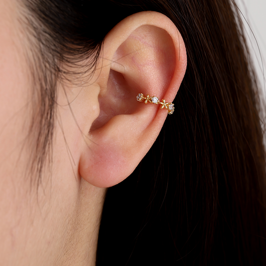 Vergoldeter Ear-Cuff mit feinen Blumenmotiven und Diamantakzenten am Ohr getragen
