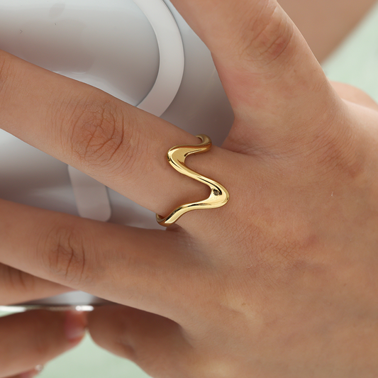 Goldfarbener Edelstahlring in Herzschlag-Design auf Finger getragen