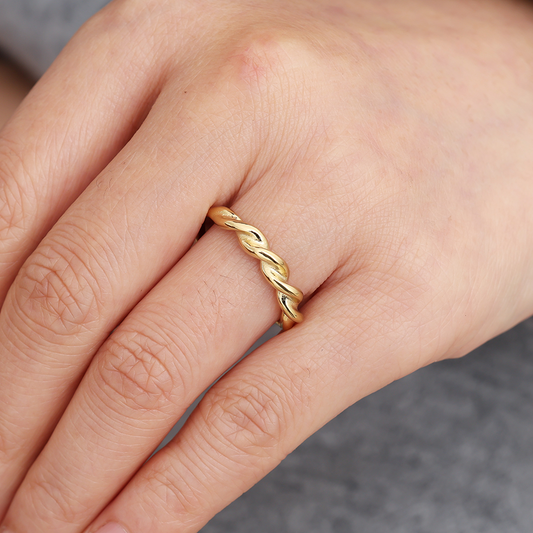 Goldfarbener Edelstahlring mit feinem Twist-Design auf Finger getragen