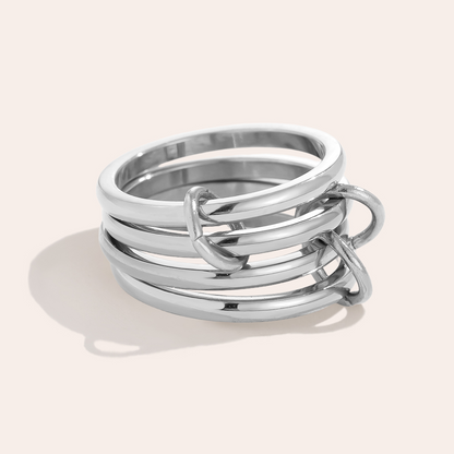 Silbernes Edelstahl-Ringset, bestehend aus mehreren ineinander verschlungenen Ringen, glänzende Oberfläche