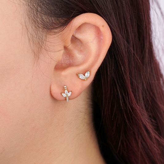 Edelstahl-Ohrringe mit diamantförmigen Blütenblättern, an Ohrläppchen getragen, glänzende Oberfläche, elegantes Design