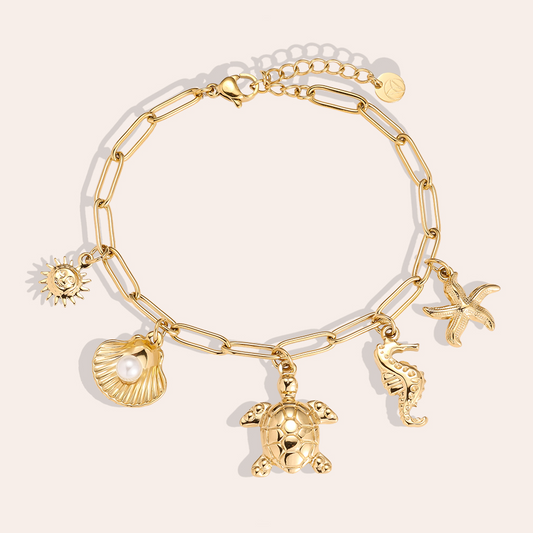 Goldfarbenes Edelstahlarmband mit Meeresmotiven: Sonne, Muschel mit Perle, Schildkröte, Seepferdchen, Seestern.