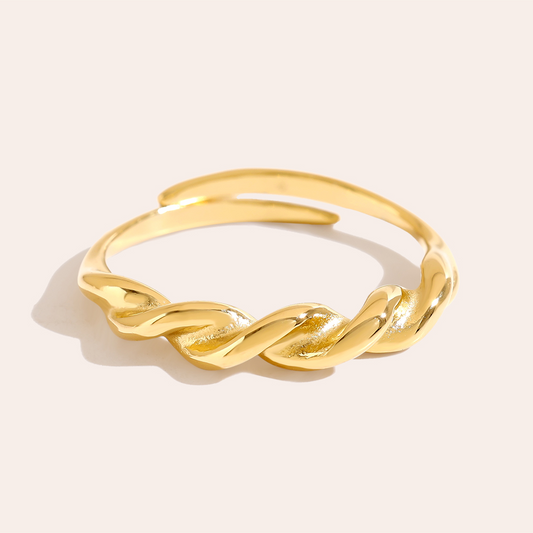 Goldfarbener Edelstahlring mit feinem Twist-Design, glänzende Oberfläche, offene Ringform