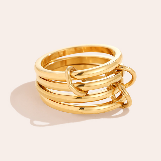 Goldenes Edelstahl-Ringset, bestehend aus mehreren ineinander verschlungenen Ringen, glänzende Oberfläche