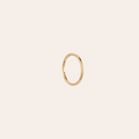 Goldenes Edelstahl-Piercing in perfekter Kreisform, schlichtes Design, glänzende Oberfläche