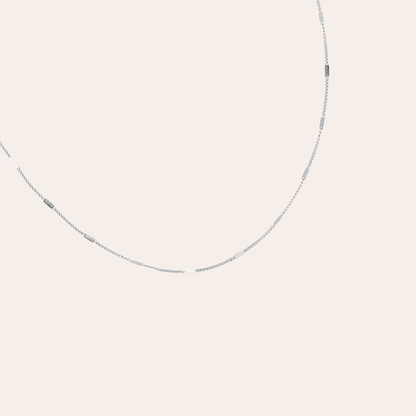Silberne Edelstahlkette mit feiner Gliederung, minimalistisch und elegant, auf hellem Hintergrund.